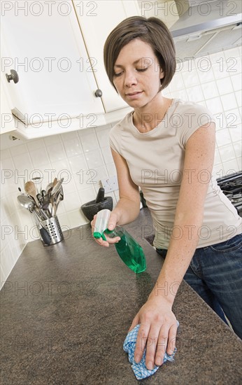 England, Cambridge, Woman cleaning kitchen counter. Photo: Justin Paget