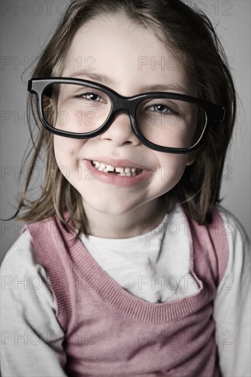 Studio portrait of girl (6-7) wearing big glasses. Photo: Justin Paget