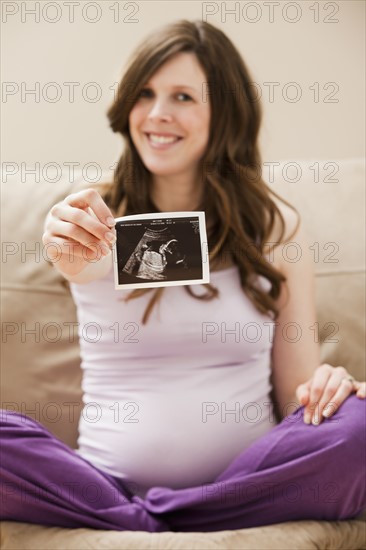 Young pregnant woman showing CT image of unborn baby. Photo: Mike Kemp