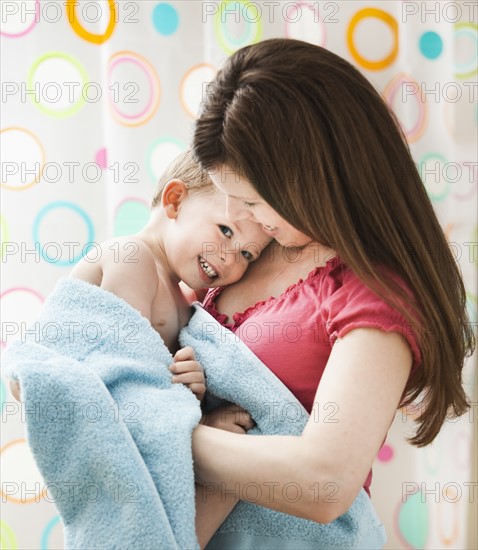 Mother with son (2-3) wrapped in towel. Photo: Mike Kemp