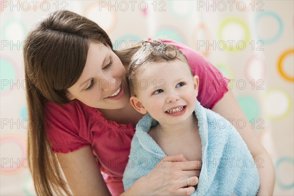 Mother with son (2-3) wrapped in towel. Photo: Mike Kemp