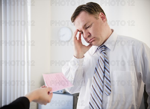 Businessman getting pink slip. Photo: Jamie Grill Photography