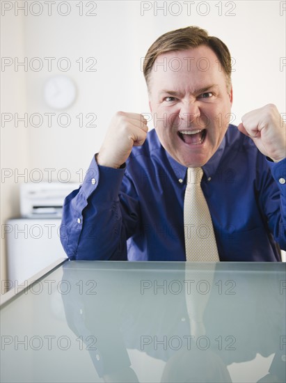 Businessman with clenched fists. Photo : Jamie Grill Photography