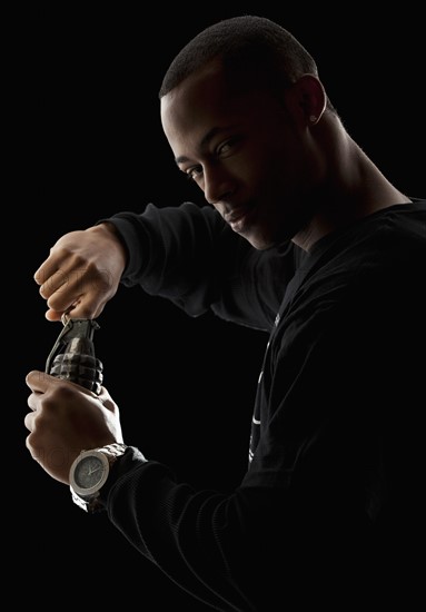 Studio portrait of young man holding grenade. Photo: Mike Kemp