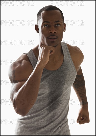 Studio shot of young man running. Photo : Mike Kemp