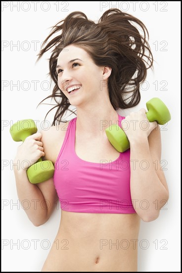 Young woman holding hand weights. Photo: Mike Kemp