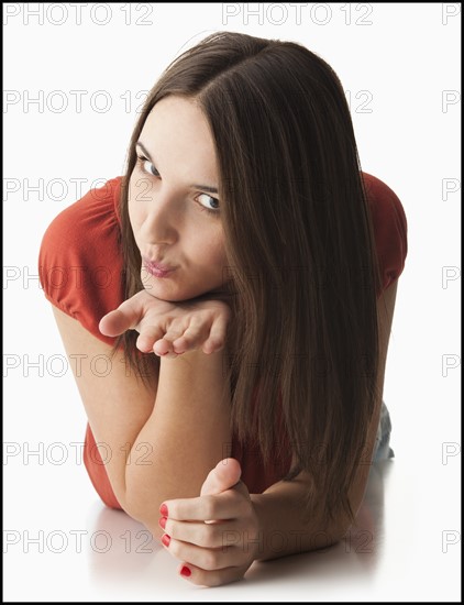 Studio portrait of young woman blowing a kiss. Photo : Mike Kemp