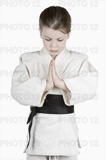 Studio portrait of girl (6-7) wearing karate uniform. Photo : Justin Paget