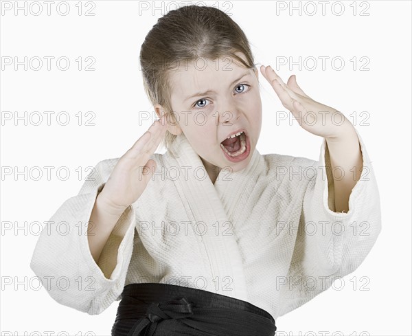 Studio portrait of girl (6-7) wearing karate uniform. Photo : Justin Paget