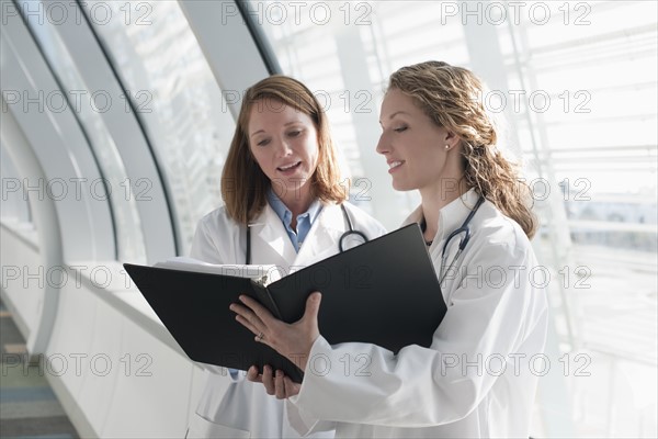 Two female doctors reading record. Photo : Mark Edward Atkinson