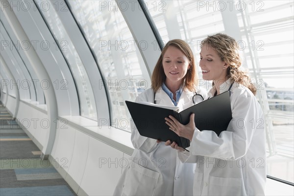 Two female doctors reading record. Photo : Mark Edward Atkinson