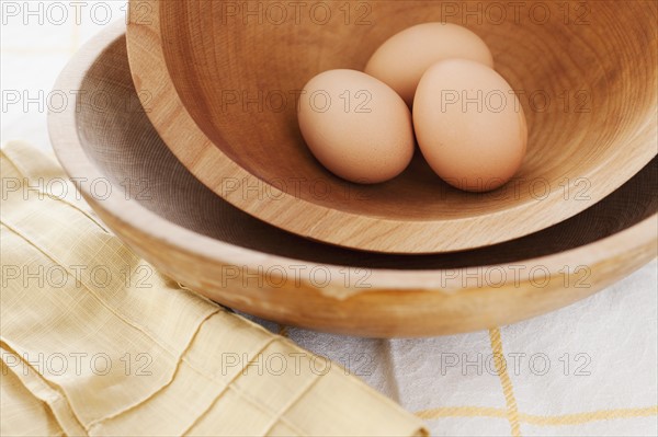 Studio shot of eggs in wooden bowl.