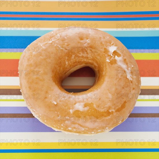 Studio shot of donut on striped background.