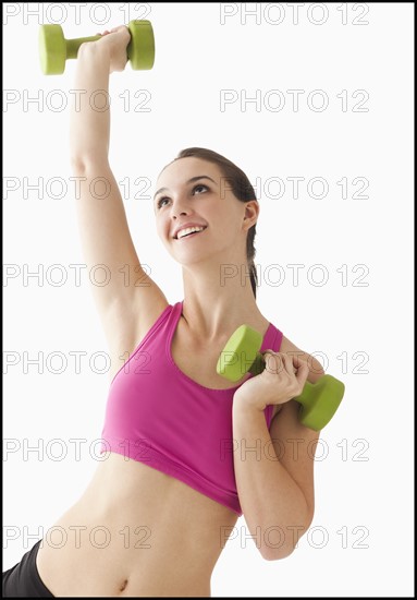 Young woman exercising with hand weights. Photo : Mike Kemp