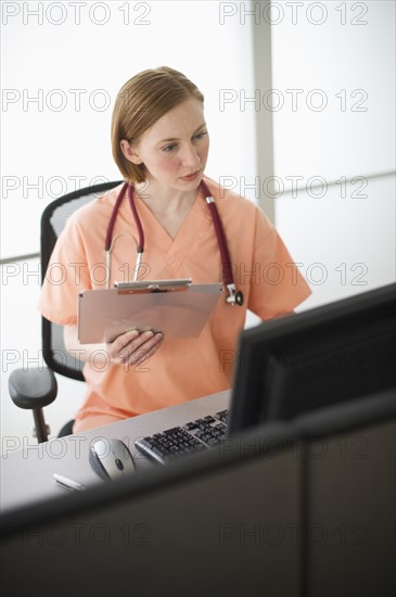 Female nurse reading medical records.