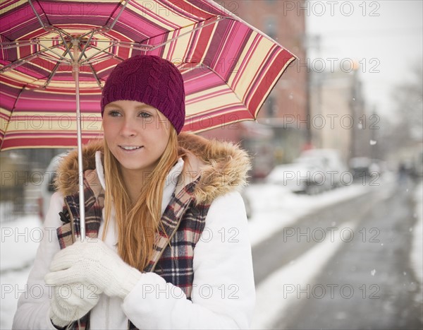 USA, New Jersey, Jersey City, woman with umbrella on street. Photo: Jamie Grill Photography