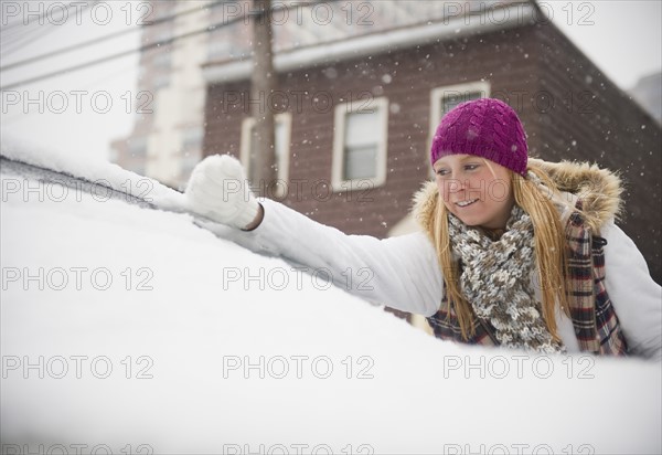 USA, New Jersey, Jersey City, woman removing snow from wind shield. Photo : Jamie Grill Photography