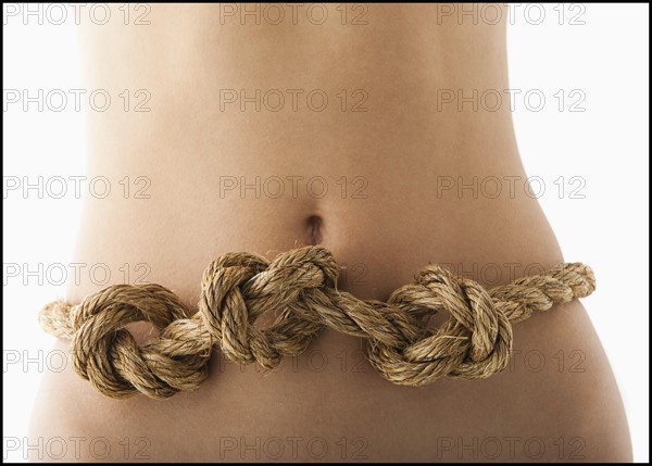 Young woman with knots in stomach. Photo : Mike Kemp