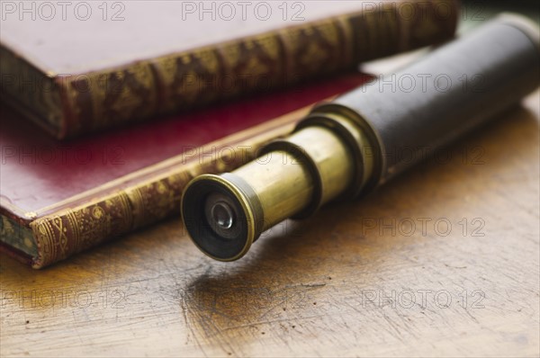 Close up of antique books and telescope.