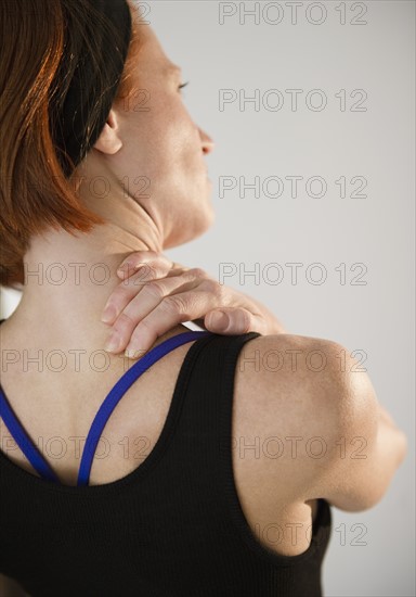 Woman rubbing neck. Photo: Jamie Grill Photography