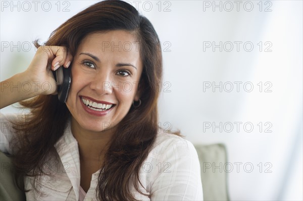 Smiling woman talking on mobile phone.