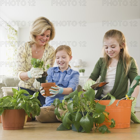 Mother and daughters (8-11) planting flowers. Photo: Jamie Grill Photography