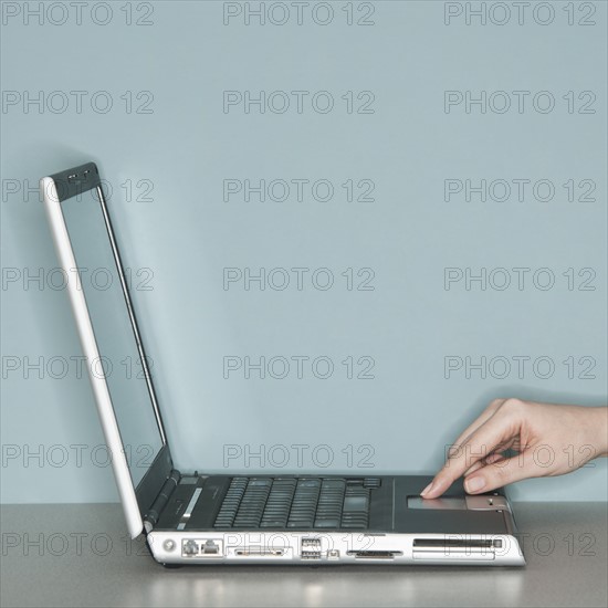 Studio shot of woman working on laptop.