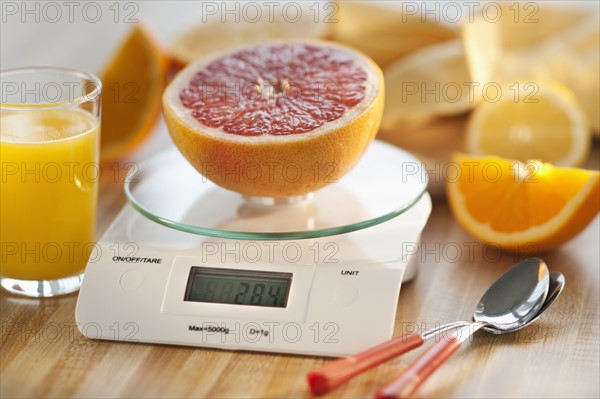 Close up of half of orange on kitchen scale.