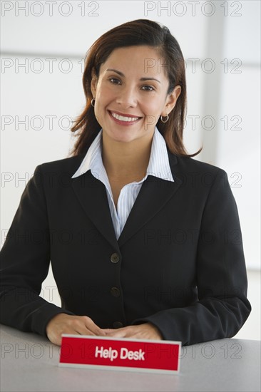 Portrait of smiling woman at customer service desk.