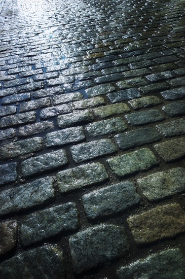 USA, New York, New York City, close up of cobblestone street at night.