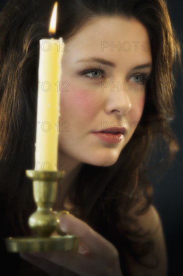 Young woman holding candle.