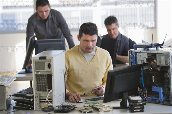 IT Professionals repairing computer in office.