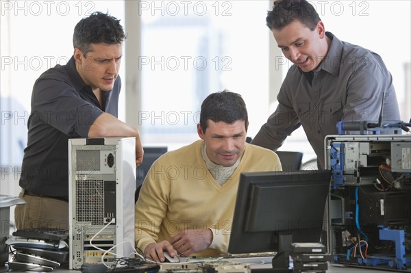 IT Professionals repairing computer in office.