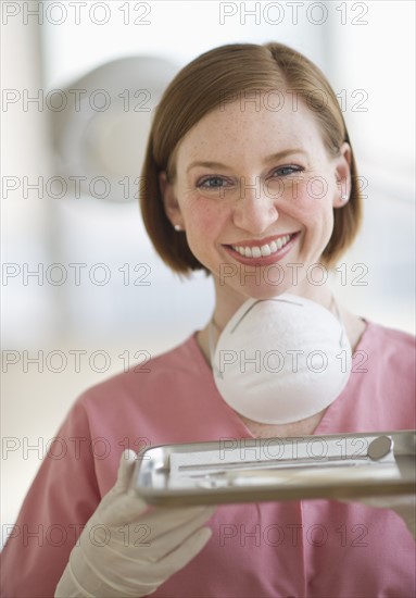 Dental assistant holding tray.