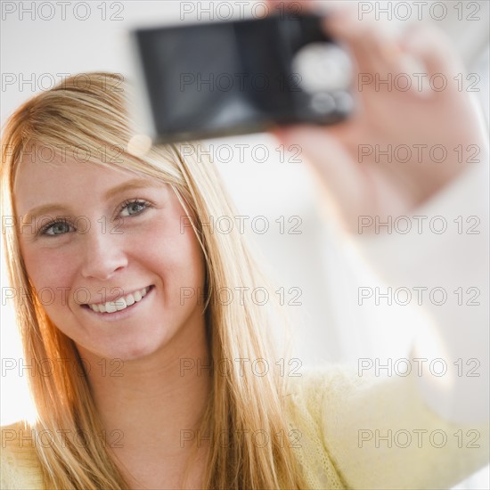 Woman photographing herself. Photo : Jamie Grill Photography