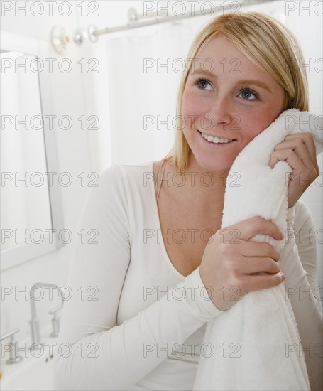 Woman drying face with towel. Photo : Jamie Grill Photography