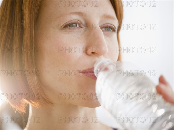 Close-up of redhead woman drinking water. Photo: Jamie Grill Photography