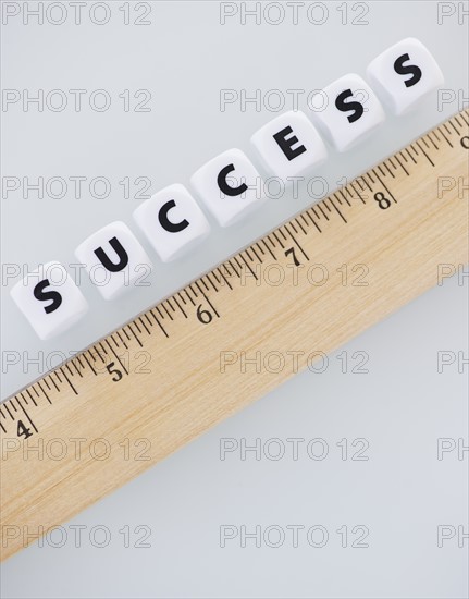 Studio shot of ruler and dice spelling out success. Photo: Daniel Grill