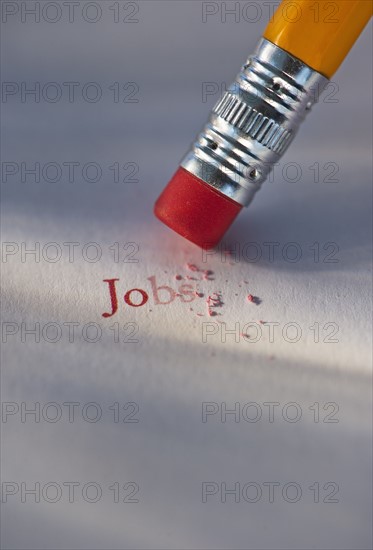 Studio shot of pencil erasing the word jobs from piece of paper. Photo: Daniel Grill