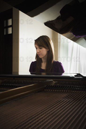 Young woman playing grand piano. Photo: Mike Kemp