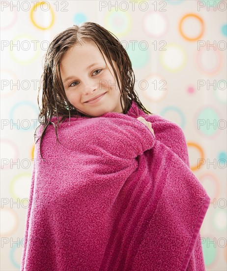 Portrait of girl (10-11) wrapped in towel. Photo: Mike Kemp