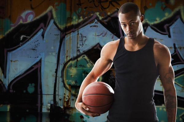 Portrait of young man with basketball. Photo : Mike Kemp