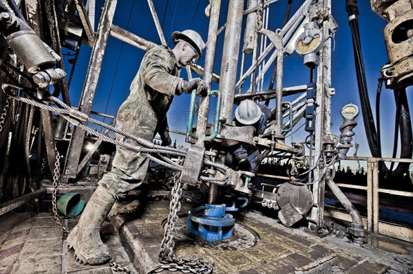 Canada, Alberta, Oil workers using oil drill. Photo : Dan Bannister