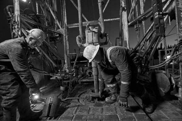 Canada, Alberta, Oil workers using oil drill. Photo : Dan Bannister