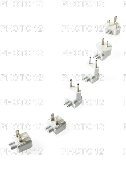 Row of plugs on white background. Photo : David Arky