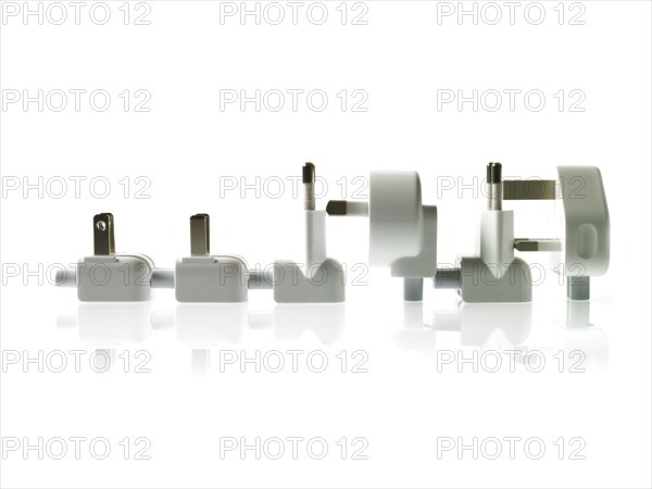 Row of plugs on white background. Photo : David Arky