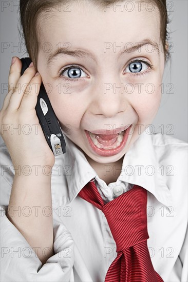 Studio portrait of girl (6-7) dressed-up as businesswoman. Photo : Justin Paget