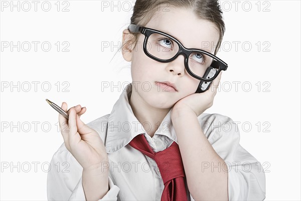 Studio portrait of girl (6-7) dressed-up as businesswoman. Photo : Justin Paget