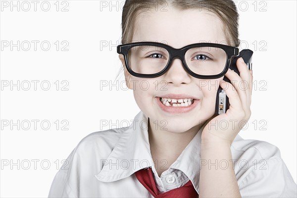 Studio portrait of girl (6-7) dressed-up as businesswoman. Photo : Justin Paget