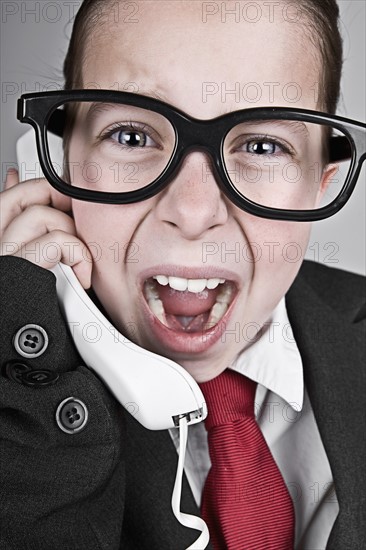 Studio portrait of girl (6-7) dressed-up as businesswoman. Photo: Justin Paget